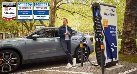 Nico Rosberg steht vor einem Elektroauto, das an einer Schnellladesäule des EnBW Hypernetz geladen wird.